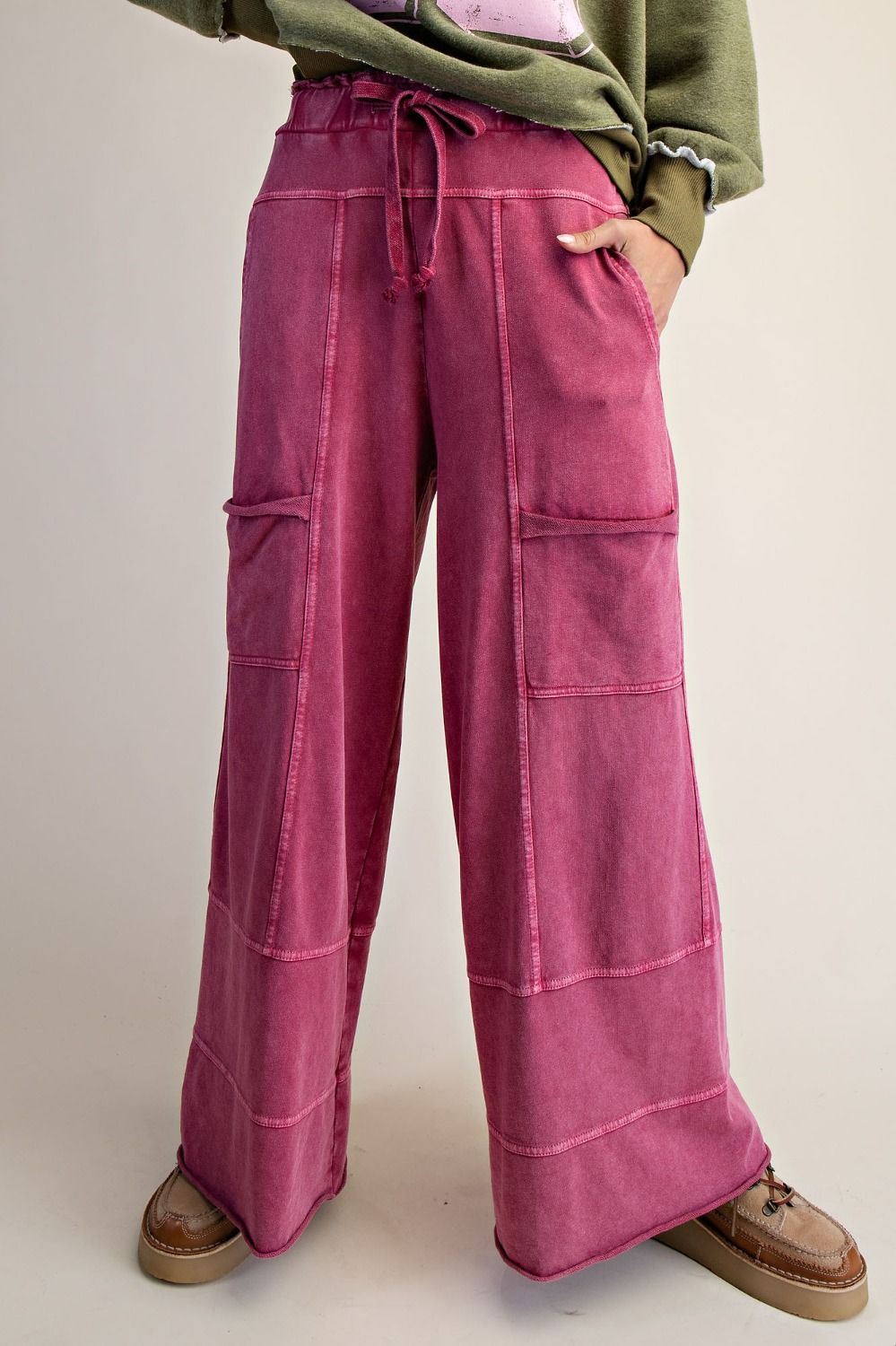 Person wearing berry colored pants with a neutral background
