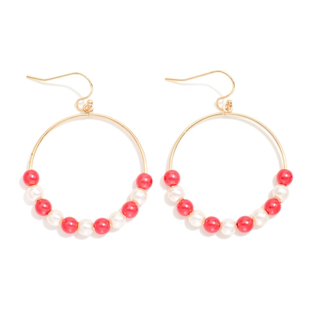 A pair of gold hoop earrings with a row of alternating red and white pearl-like beads along the bottom curve, shown on a plain white background.