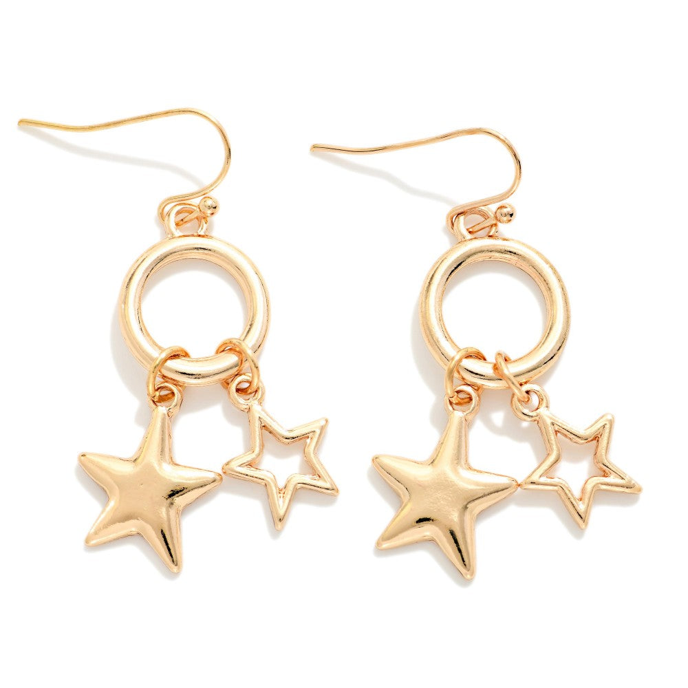 A pair of gold-toned dangle earrings with a circular ring, a larger five-point star, and a smaller five-point star charm, shown on a plain white background.