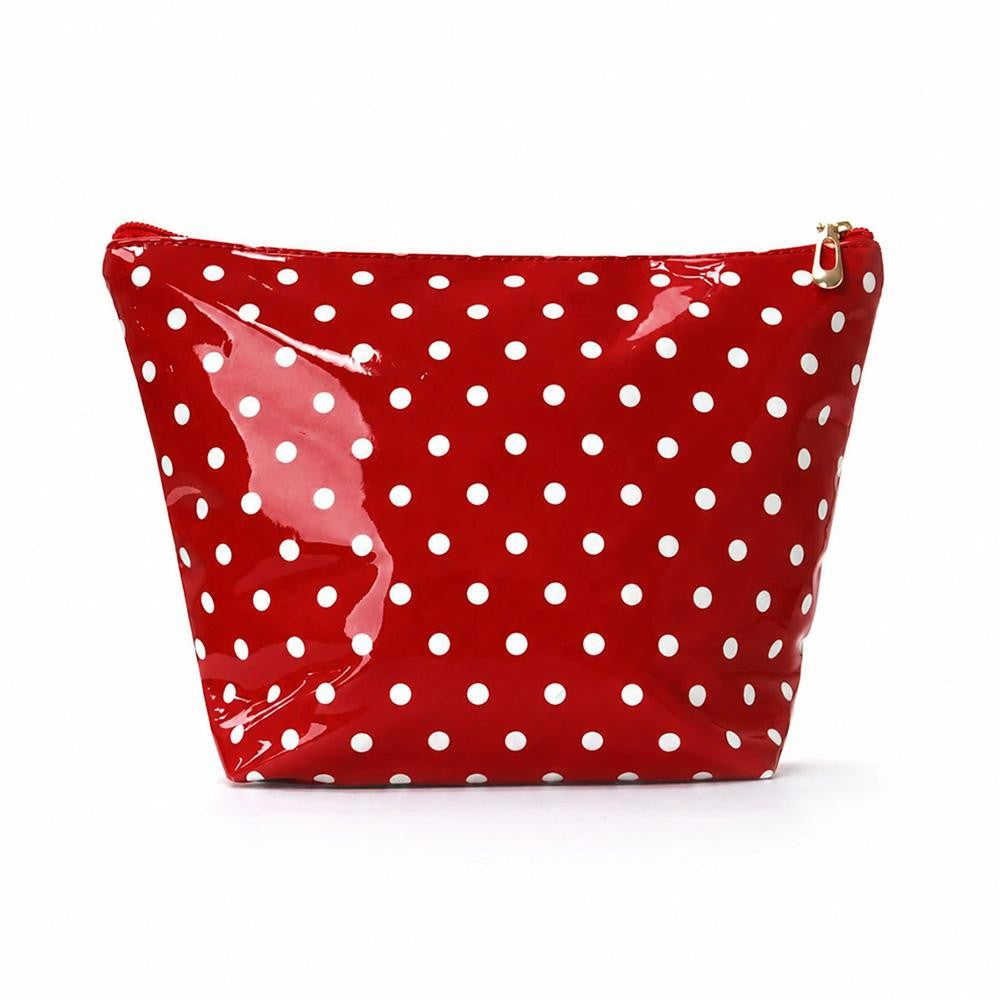 A red glossy patent leather cosmetic pouch with a white polka dot pattern and a gold zipper pull, shown on a plain white background.