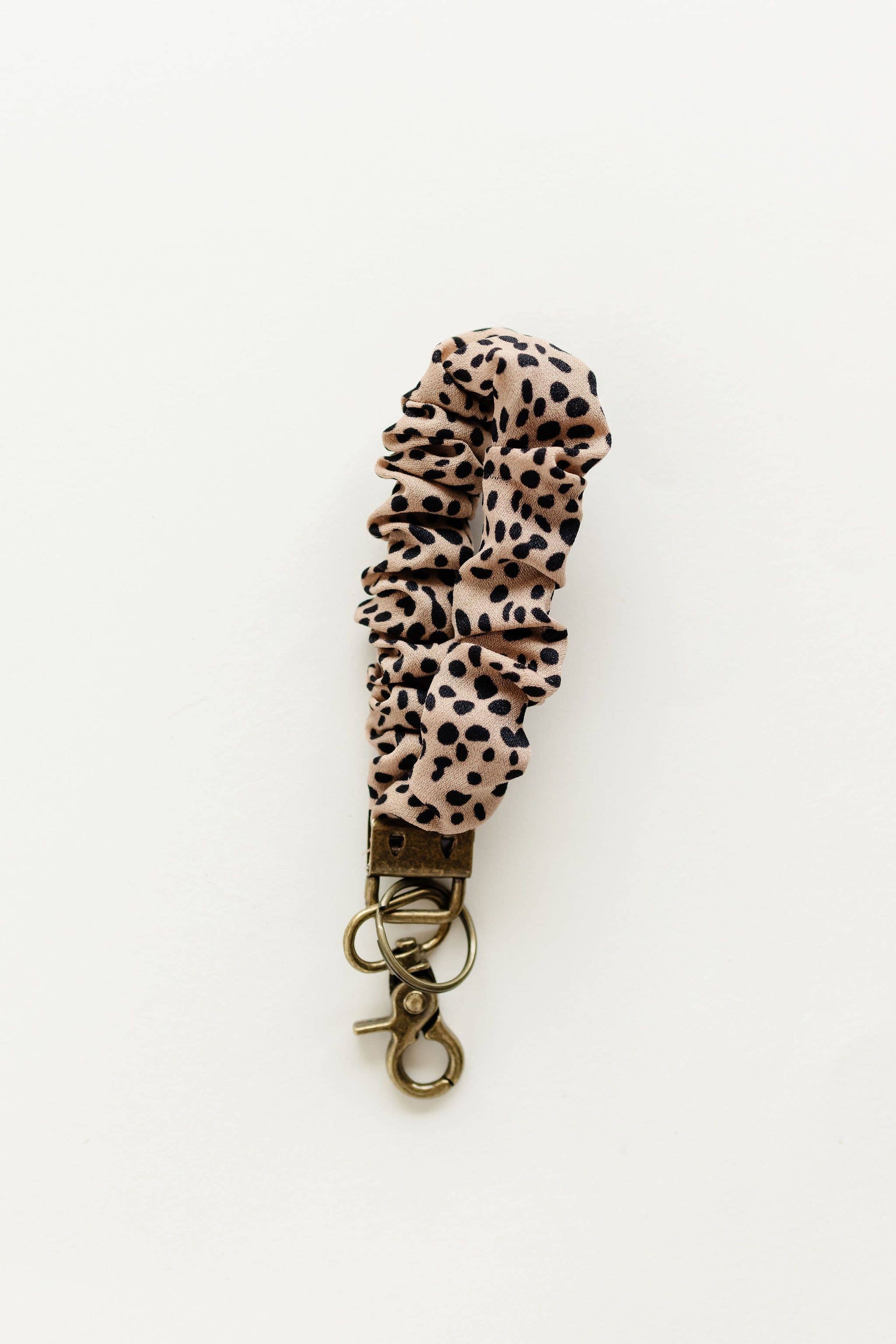 Brown key chain with black spots on a white background 