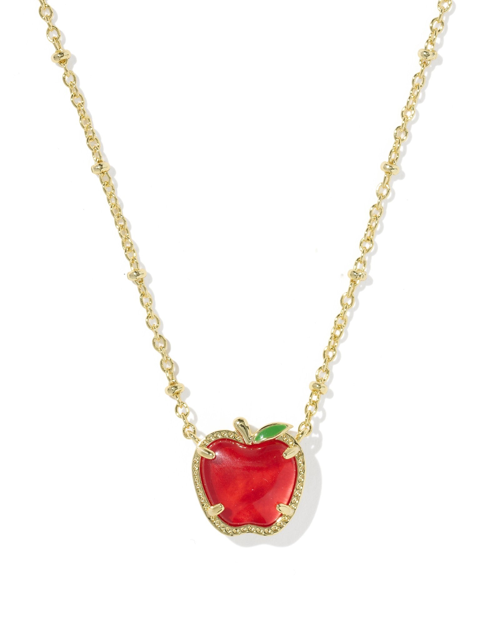 Red apple pendant necklace with gold chain on a white background