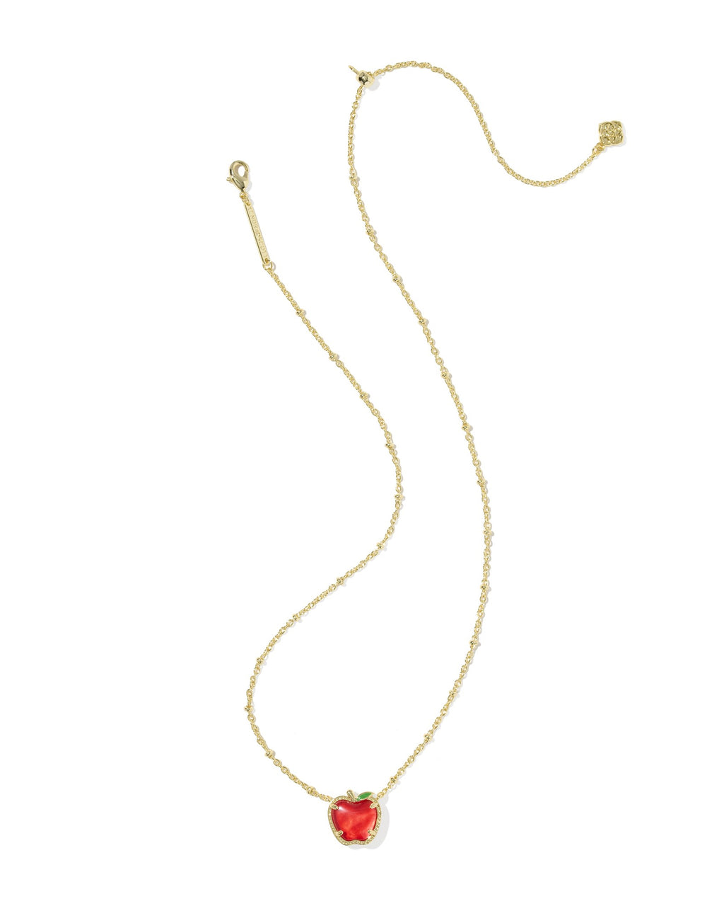 Gold necklace with a red apple-shaped pendant on a white background
