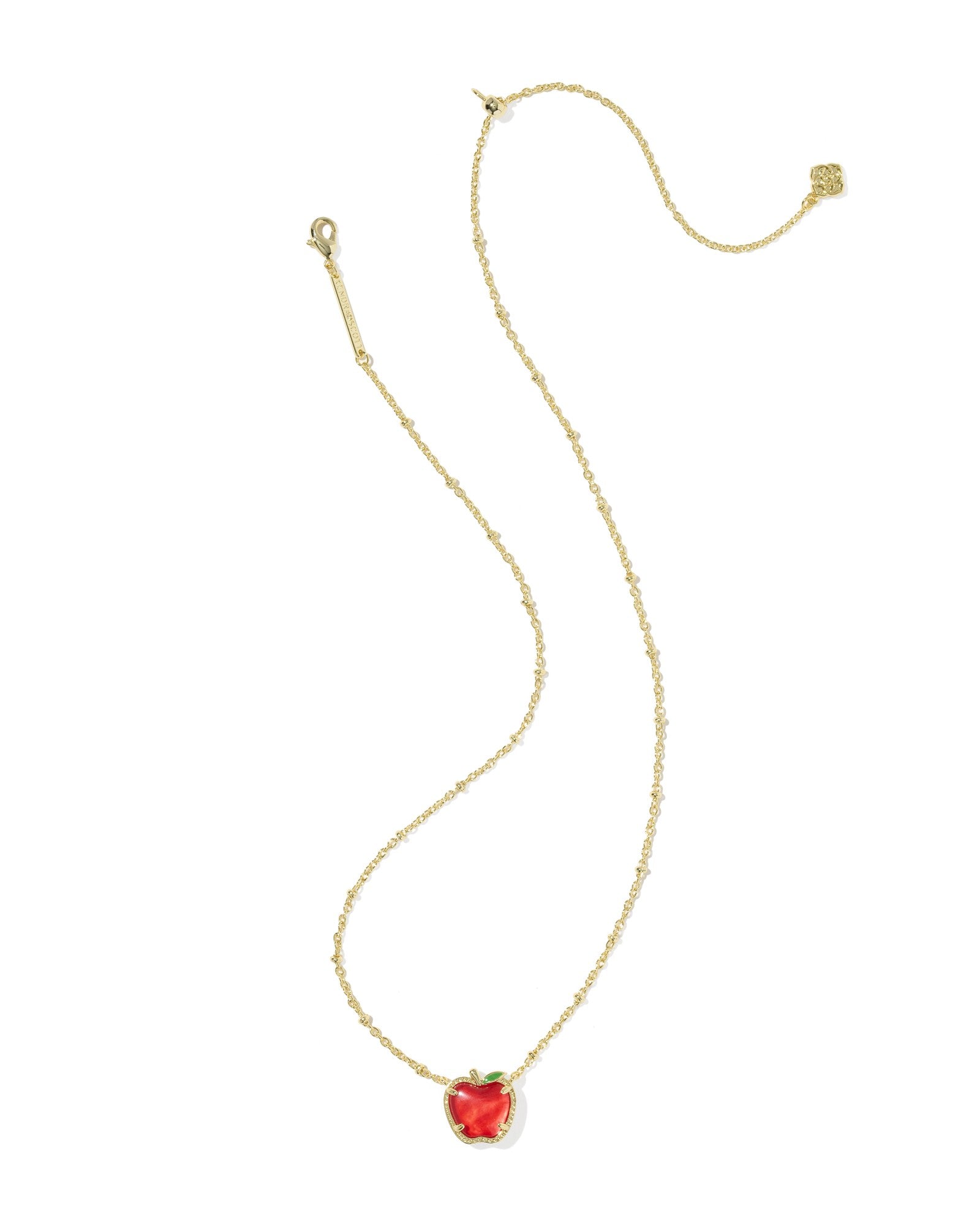 Gold necklace with a red apple-shaped pendant on a white background