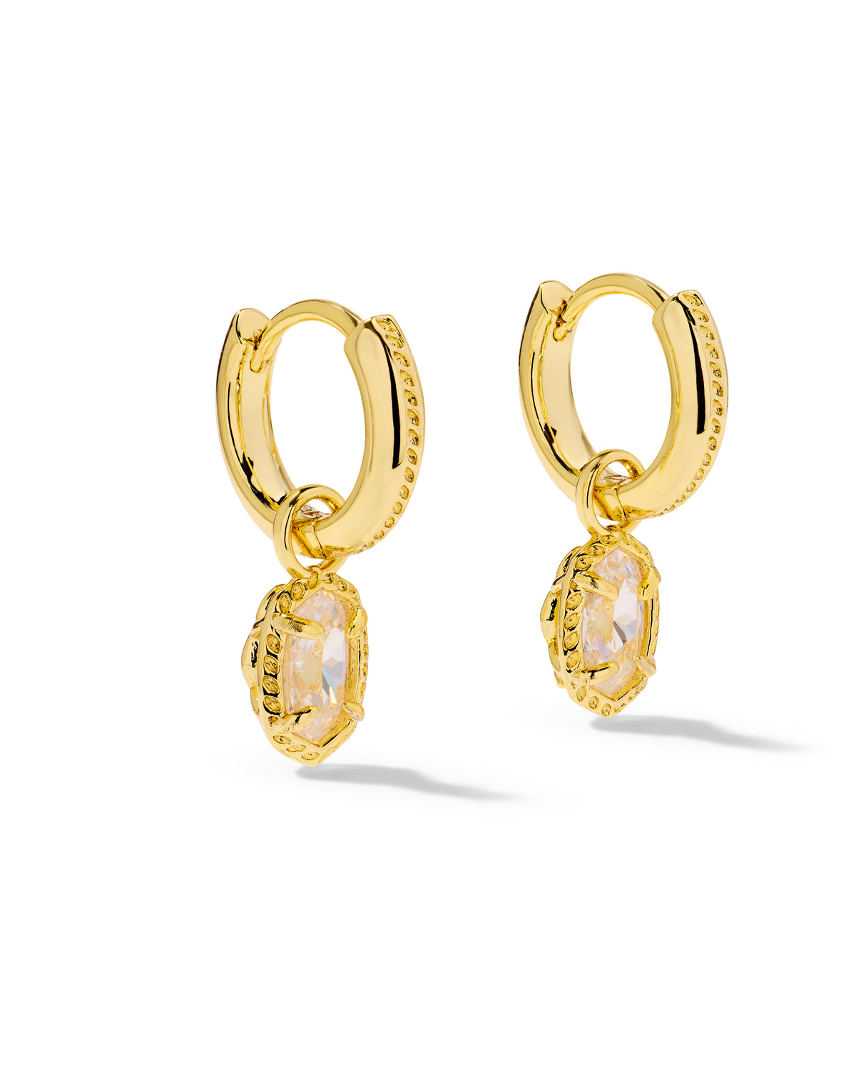 A pair of gold huggie hoop earrings with textured bezel settings holding oval iridescent cabochon gemstones, shown on a clean white background.