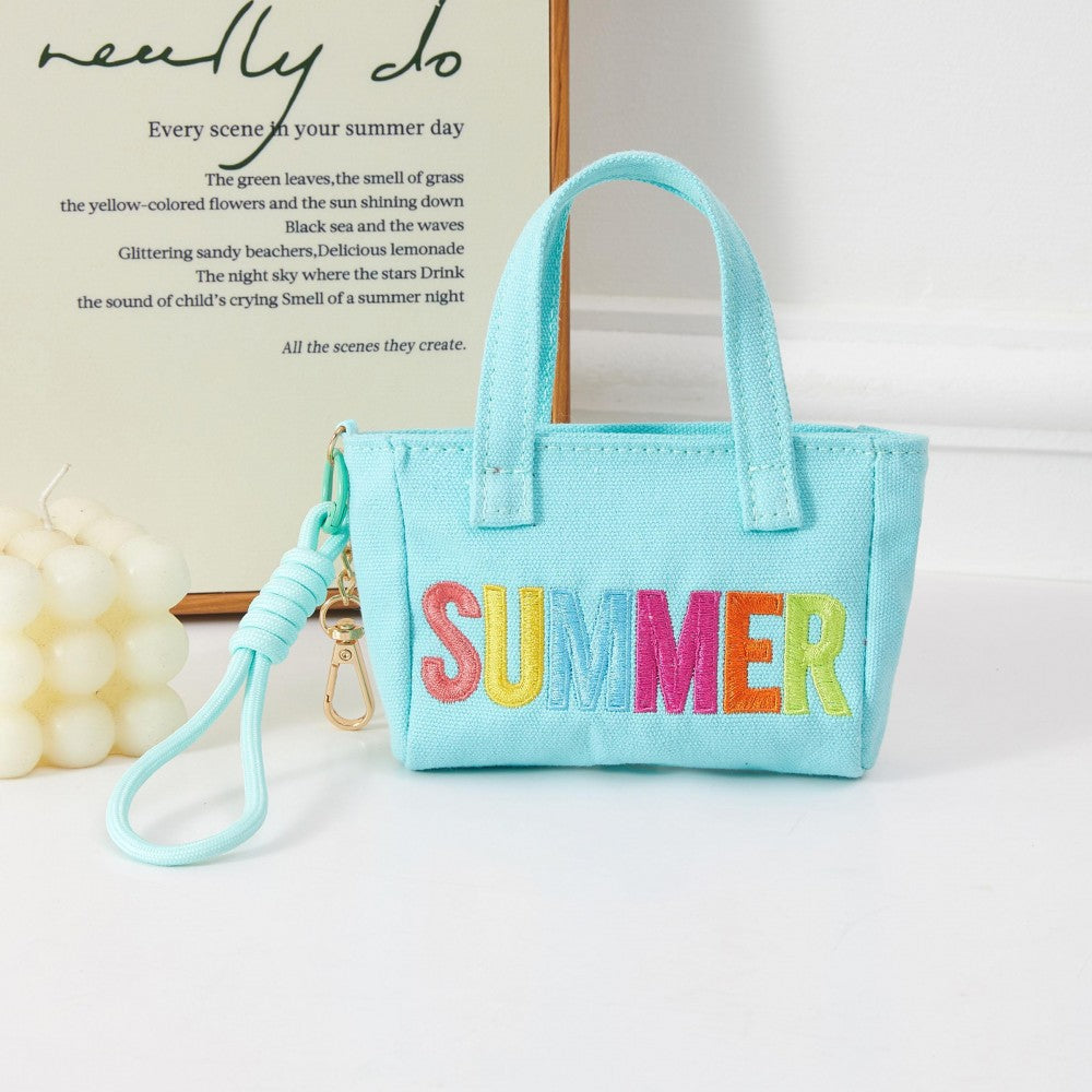 Light blue miniature handbag with “Summer” embroidered on one side with neon letters. 