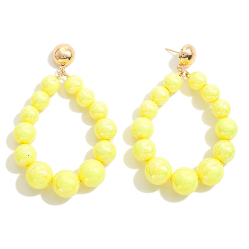 Yellow beaded hoop earrings with gold accents on a white background