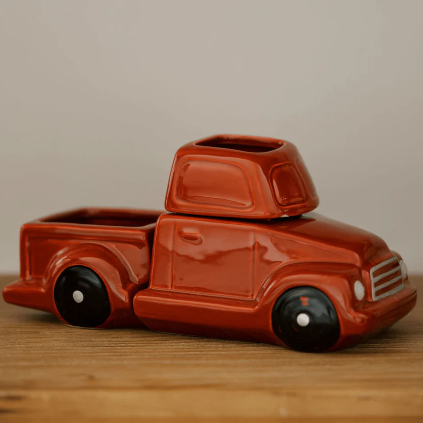 A glossy, fire-truck-red, ceramic wax warmer designed to look like a vintage truck.