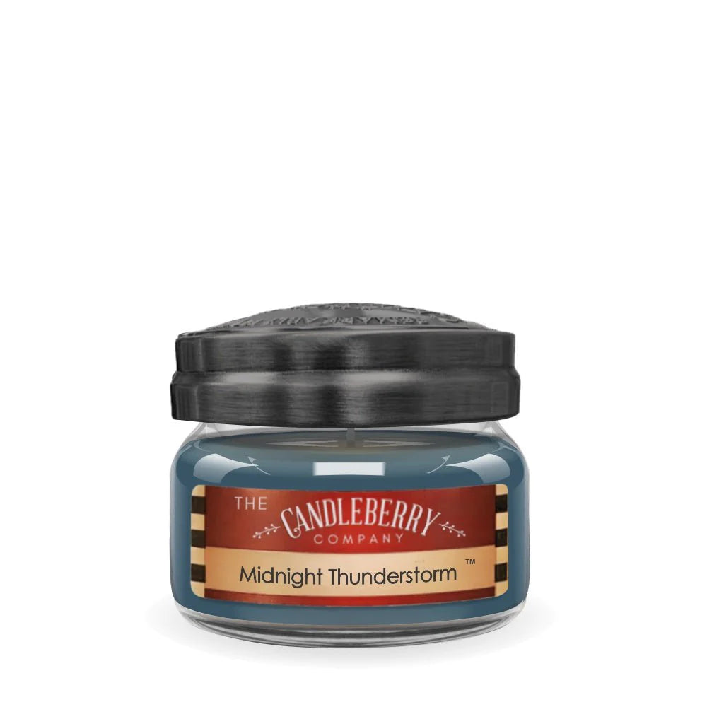 A small jar candle with a black lid, blue tinted glass jar, and a label that reads 'Midnight Thunderstorm'.