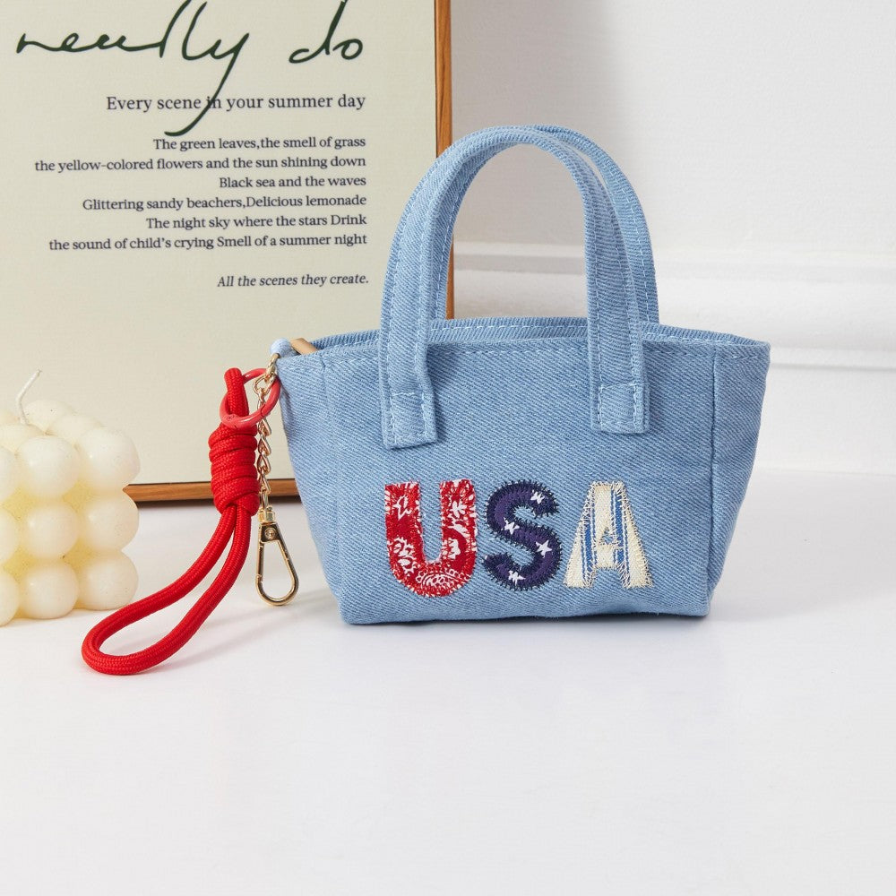 Denim miniature handbag with USA embroidered in red, blue, and white. 