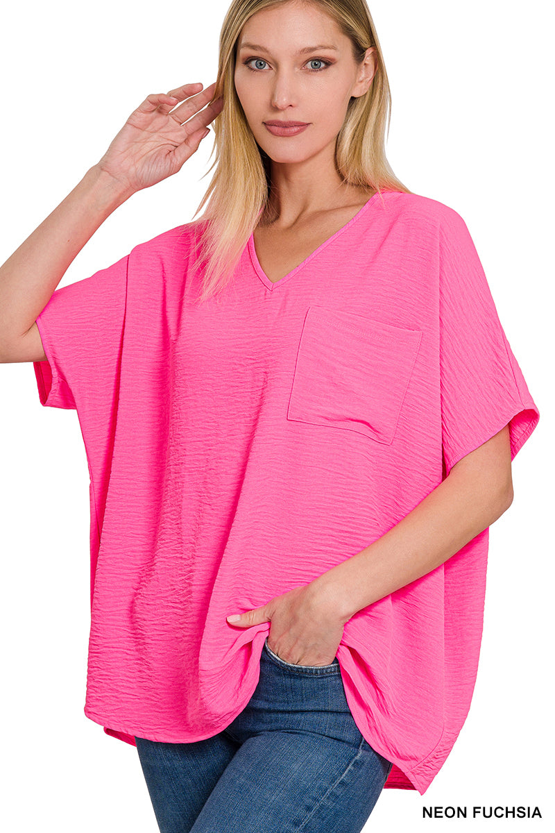 Woman wearing neon pink shirt with blue jeans on a white background.