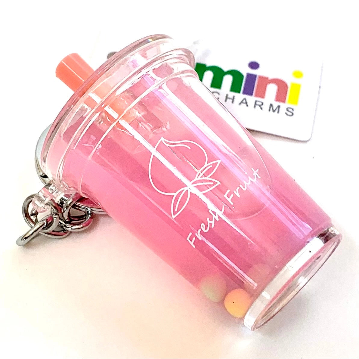 Pink fruit cup keychain with 'mini charms' tag in the background