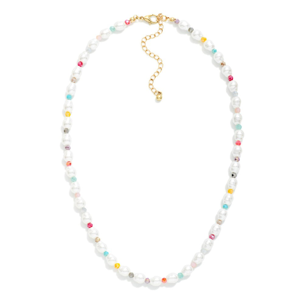 Pearl and rainbow beaded necklace with gold clasps on a white background. 