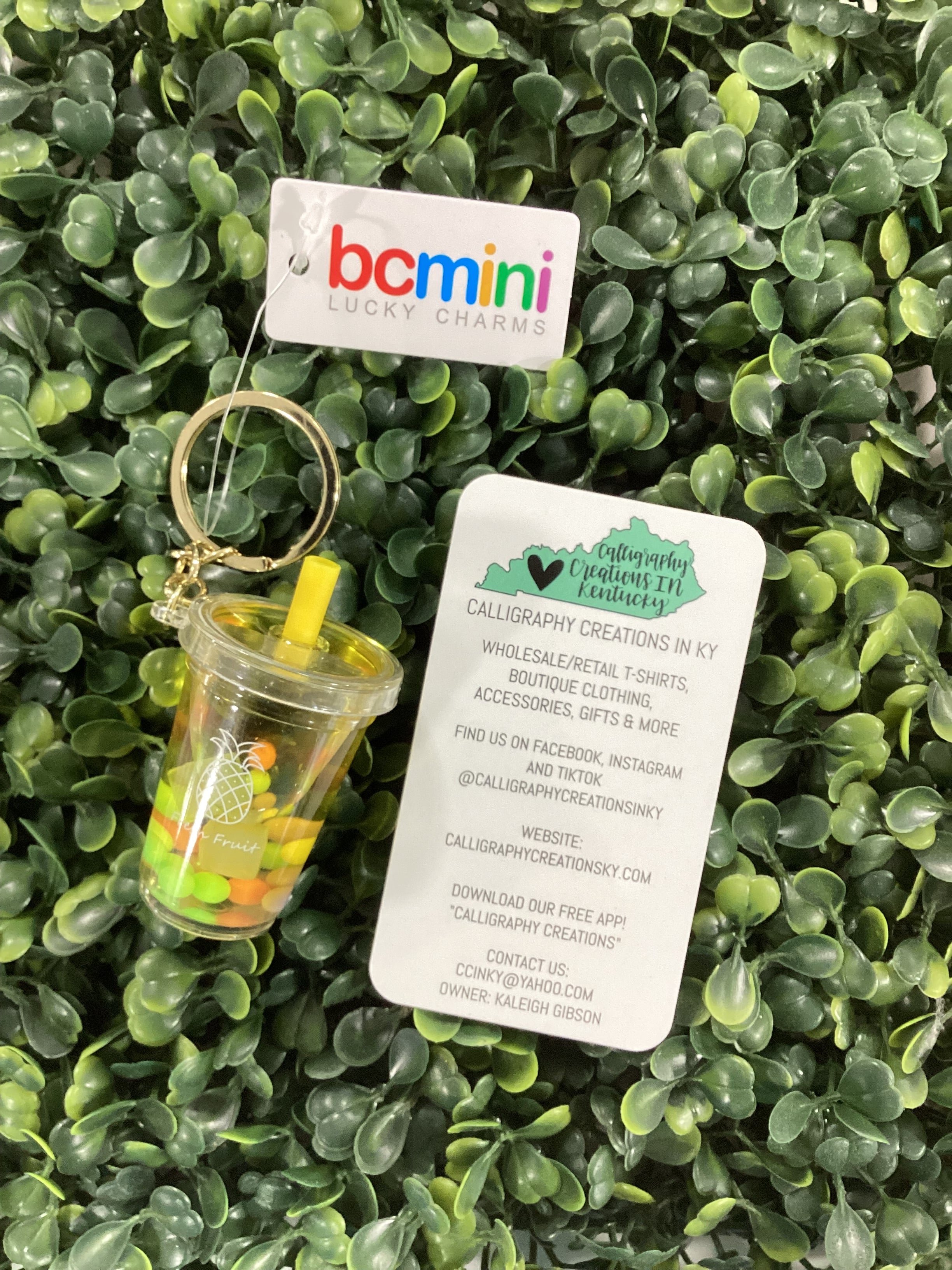 Keychain with cup design on a green leafy background