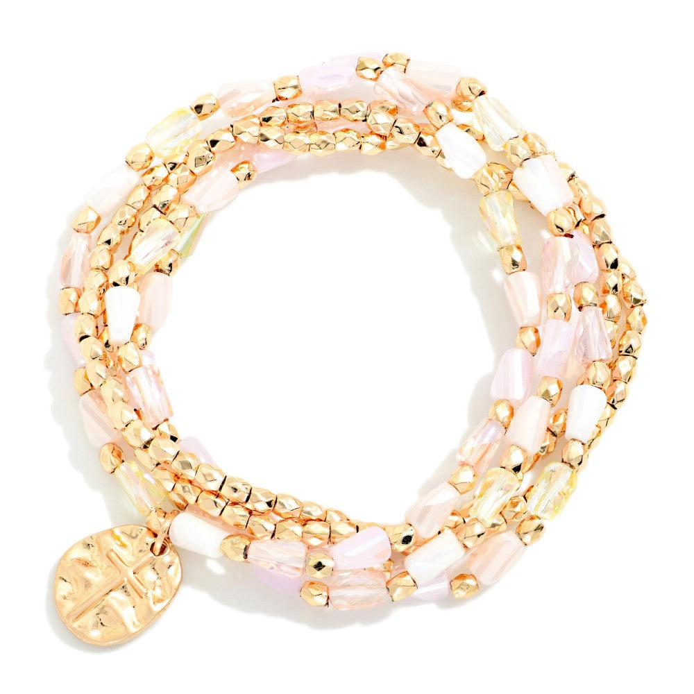 Beaded bracelet set featuring gold and pink beads on a white background 
