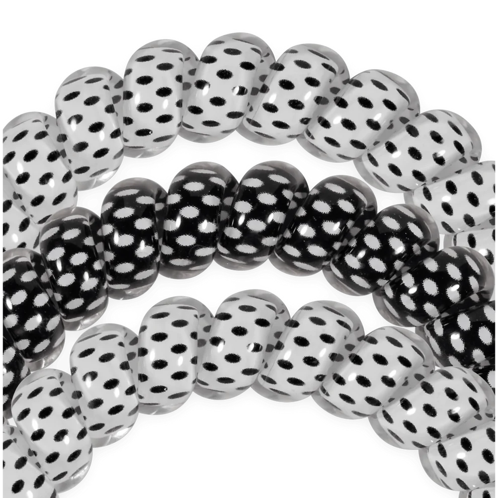 Set of black and white polka dot hair ties on a white background