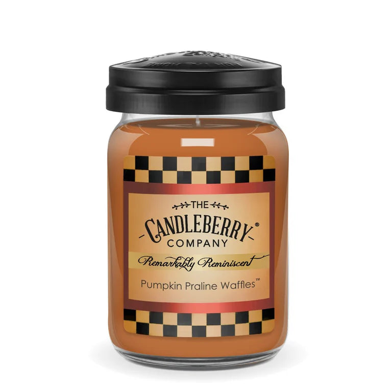 A large jar of pumpkin praline waffles scented candle with a black lid and a label that reads 'The Candleberry Company'.