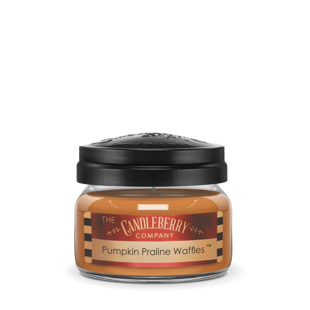 A small jar of Candleberry Company Pumpkin Praline Waffles scented candle with a black lid on top.