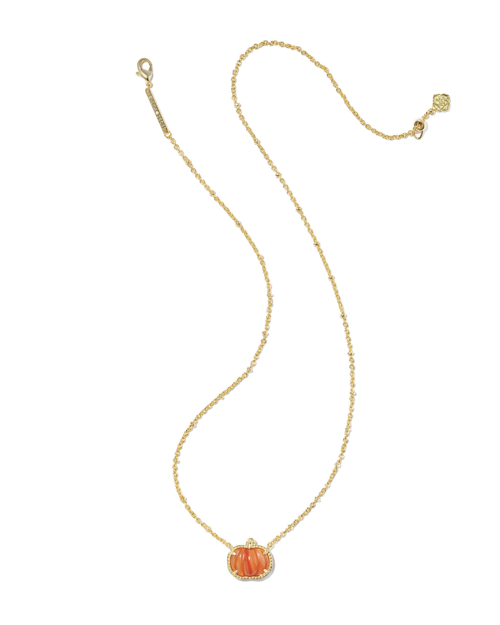 A delicate gold chain necklace featuring a small orange pumpkin pendant with a halo of clear stones, displayed on a clean white background.