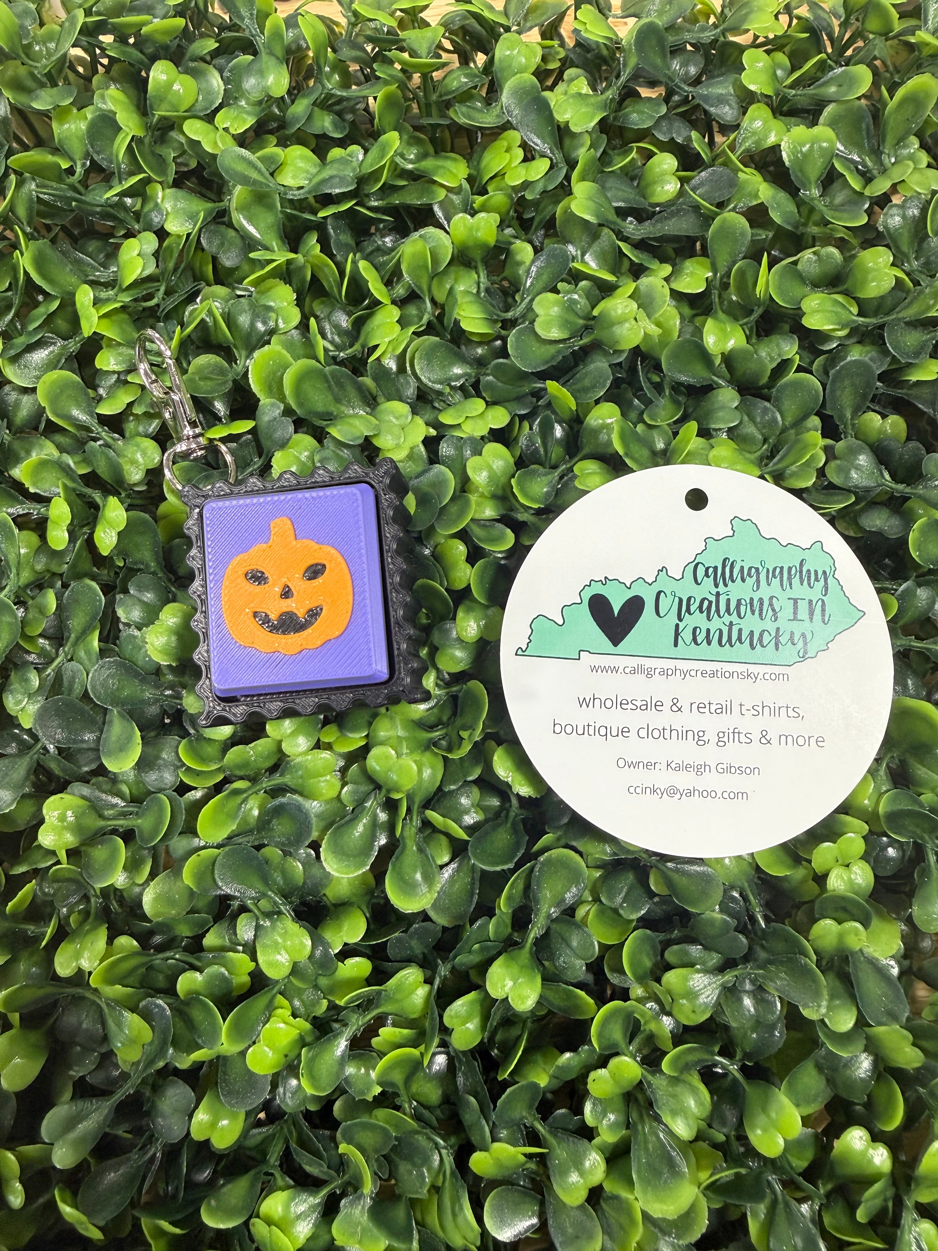 Pumpkin stamp keychain on a green leafy background