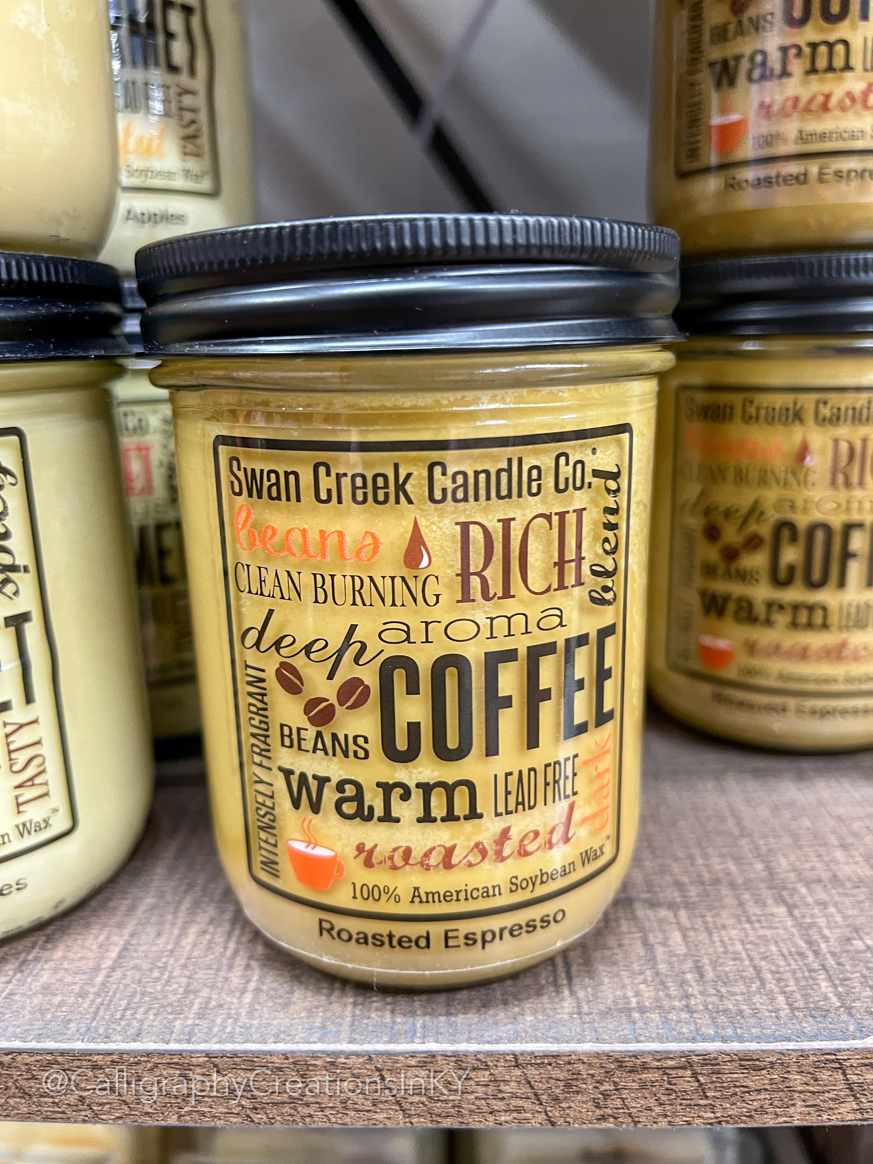 A jar candle with a label reading 'Swan Creek Candle Co., rich aroma, deep coffee beans, roasted espresso, 12 oz.'
