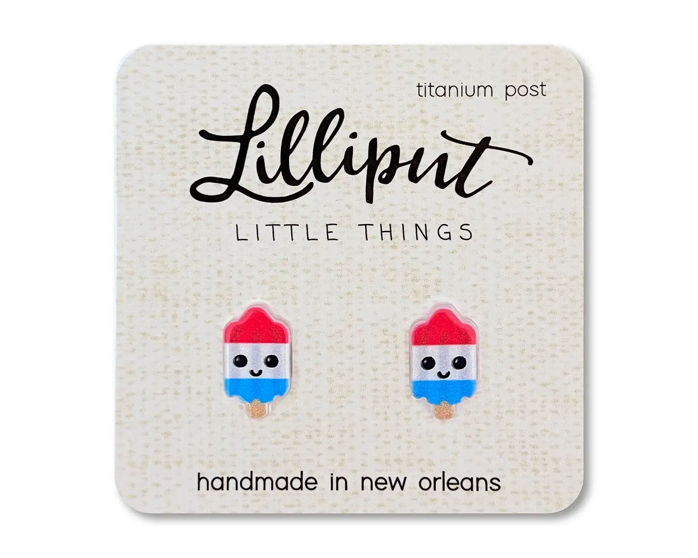 Rocket pop shaped earrings on beige card on white background 