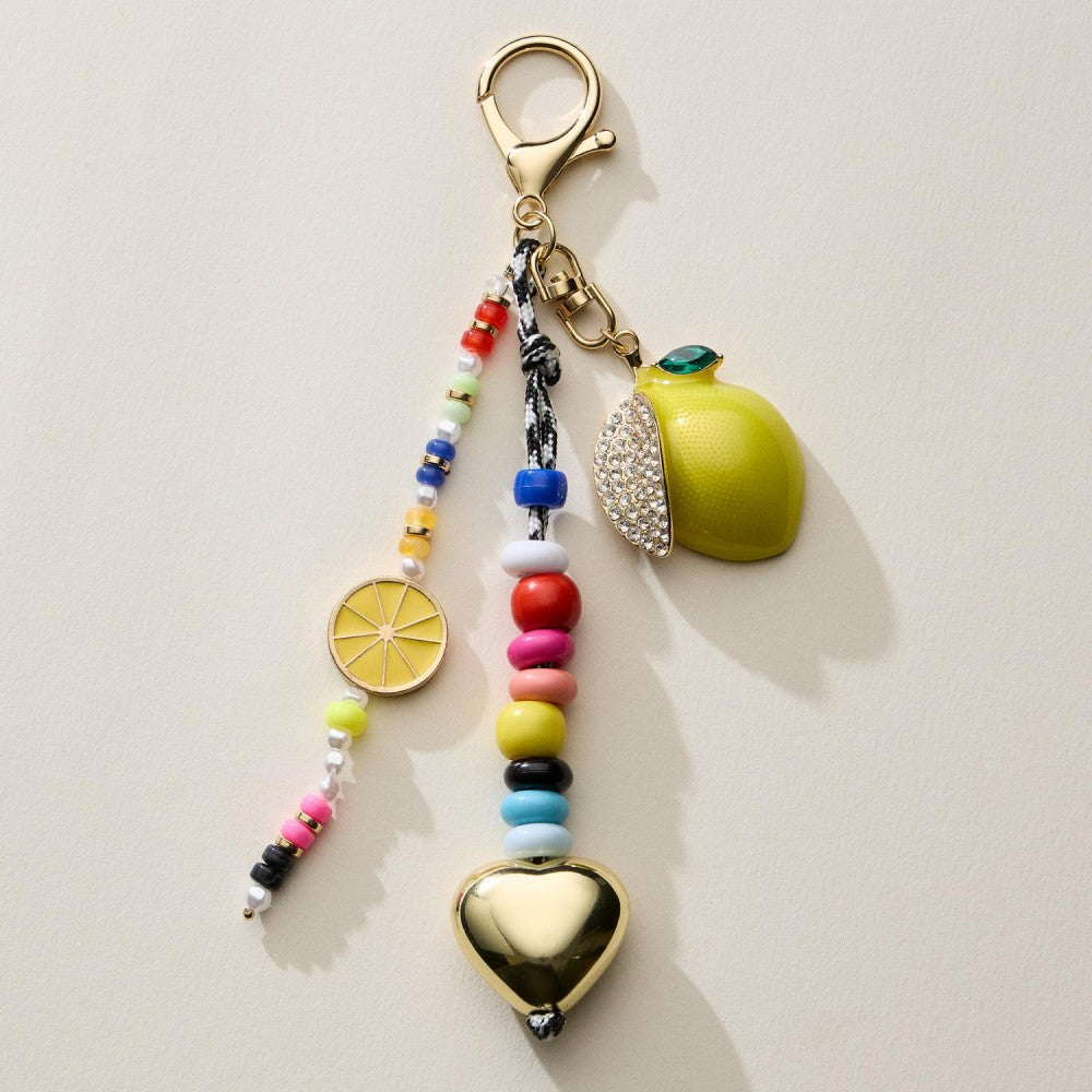 Beaded key chain with lemon and heart charms on a beige background. 