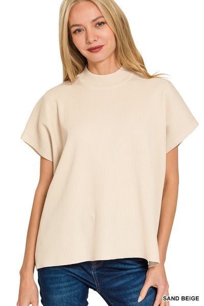 Woman wearing a sand beige t-shirt and blue jeans on a white background