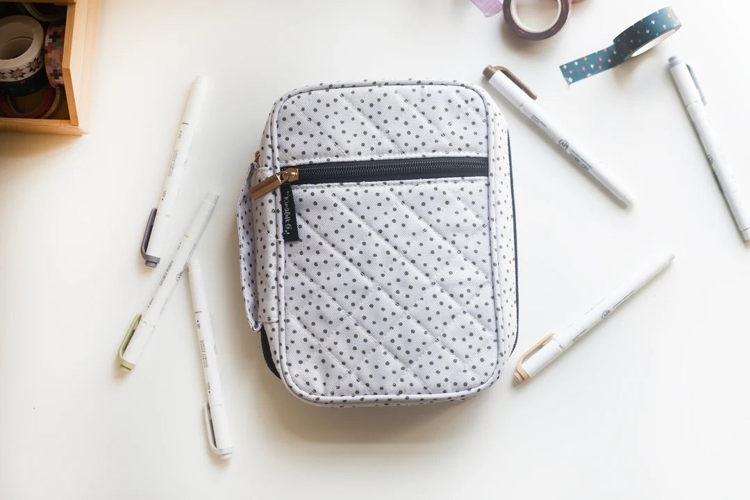 Polka dot Bible case on a white surface with stationery items 