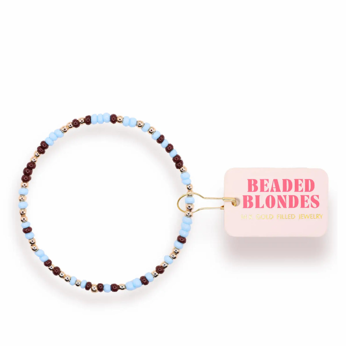 A beaded stretch bracelet with light blue, dark brown, and gold beads, shown with its pink tag that reads 'BEADED BLONDES'.