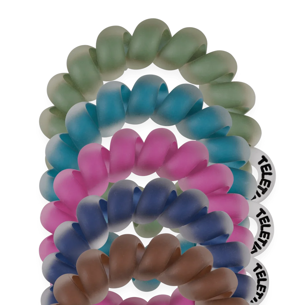 A set of silicone spiral hair ties stacked vertically on a white background, featuring a color gradient from top to bottom in sage green, teal, pink, blue, and brown. One white tie on the right displays the brand name 'RELENT' in black text.