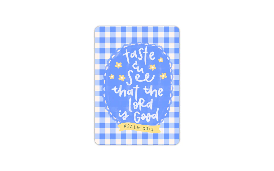 A rectangular decorative plaque or sign with rounded corners, featuring a blue and white gingham border and a central blue oval with the hand-lettered quote 'taste and see that the Lord is good' and a small yellow banner reading 'PSALM 34:8'.