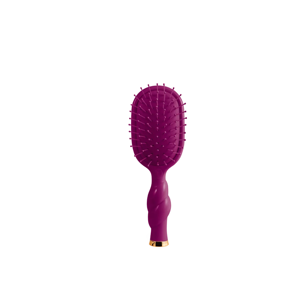 A purple paddle hairbrush with flexible bristles and a twisted handle, featuring a small gold accent at the base, shown against a plain white background.