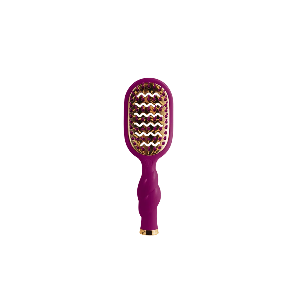 A purple and gold hairbrush with a textured handle and metallic bristles, centered on a plain white background.