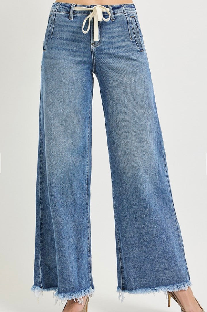 Light blue wide-leg denim jeans with a drawstring waistband and frayed hems, shown on a model against a plain light background.