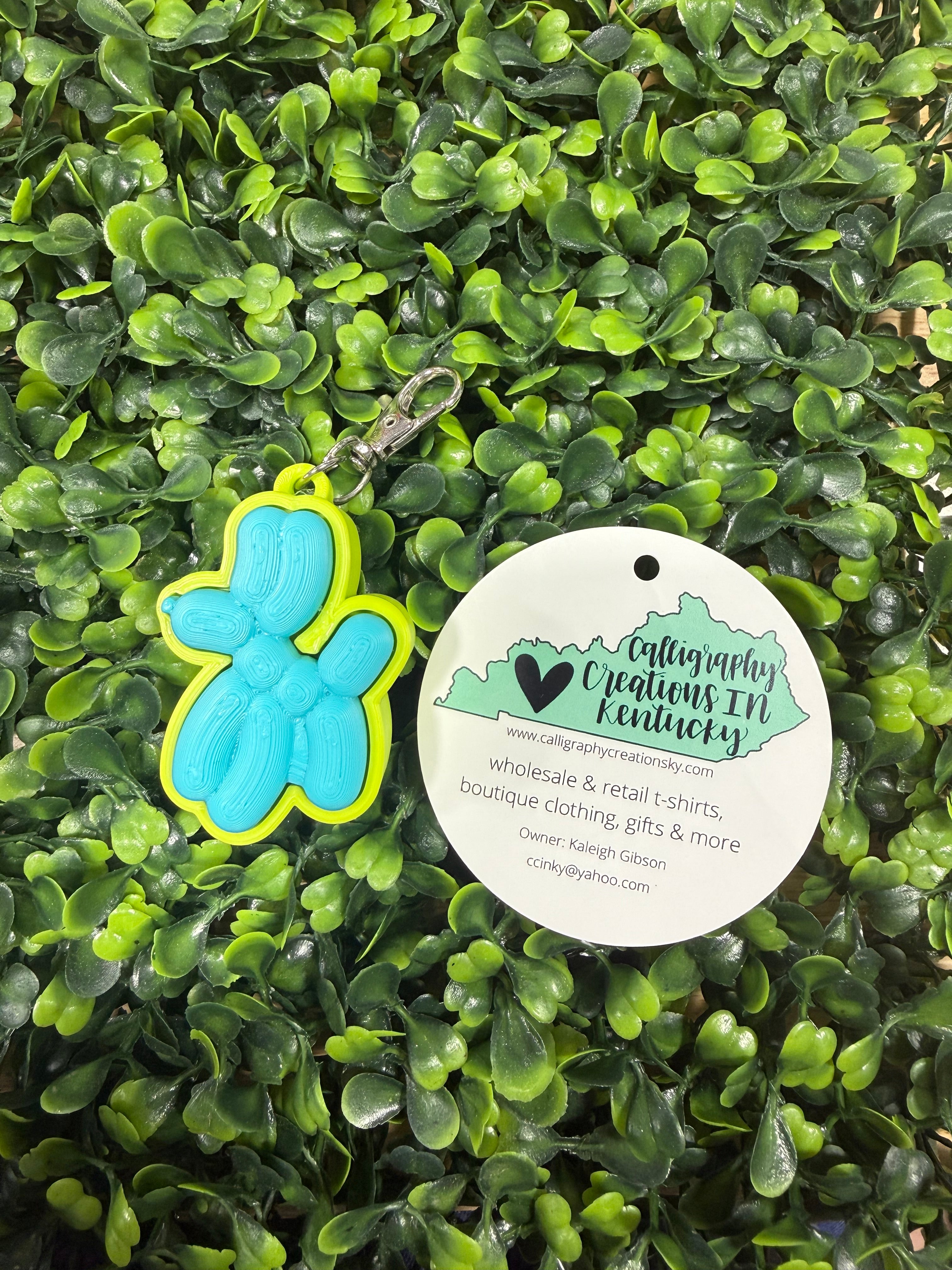 Balloon dog keychain on a leafy background