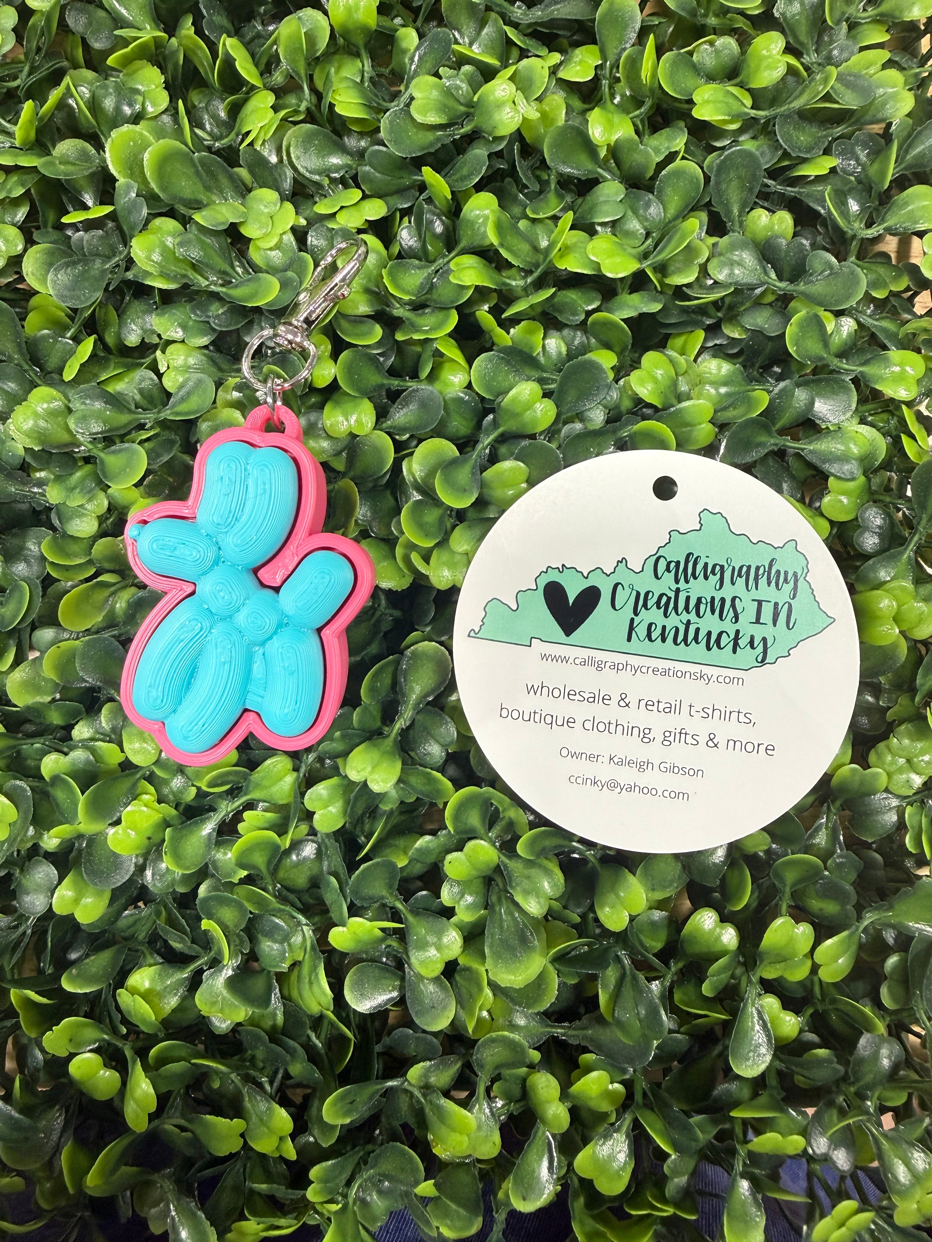 Balloon dog keychain on a leafy background